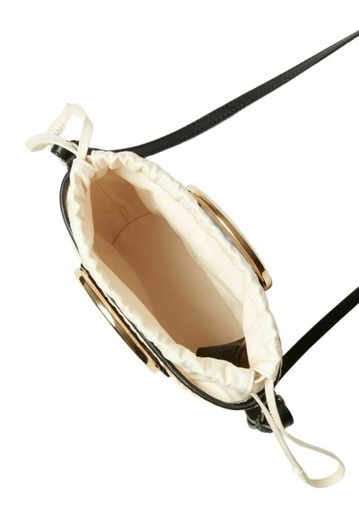 Borsa a mano in pelle nera con chiusura a coulisse, dotata di una fodera in tessuto color crema e dettagli in metallo dorato. Ha una lunga tracolla attaccata.