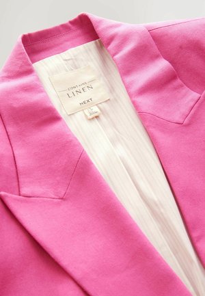 Blazer in lino rosa con colletto a punta, caratterizzato da una fodera a righe beige e un'etichetta che riporta "contiene lino" del marchio Next.