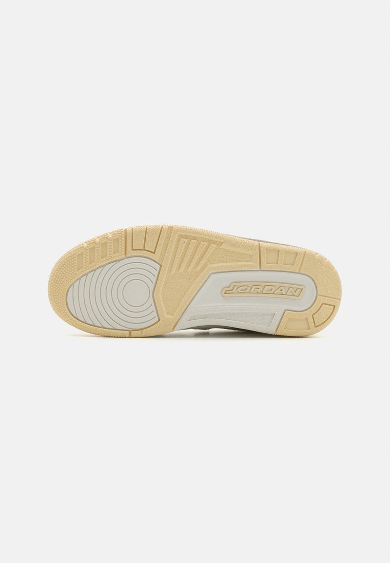 Suela de zapato de goma con un patrón texturizado, de color beige y elementos de diseño circulares. Acento grabado "JORDAN" en el lado.