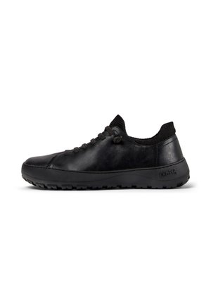 Black leather sneaker with a rounded toe, flat laces, and textured collar. Flexible rubber sole with grip pattern and embossed logo detail.
