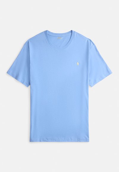 Šviesiai mėlynas medvilninis marškinėlis trumpomis rankovėmis, apvalia iškirpte ir mažu geltonu siuvinėtu logotipu kairėje krūtinės pusėje. Minkšta tekstūra.
