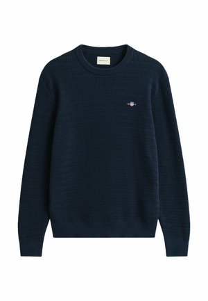 Marineblauwe gebreide trui met een gestructureerd patroon, ronde halslijn en een klein logo op de borst. Lange mouwen en ribgebreide boorden en onderrand.