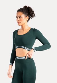 Crop top met lange mouwen in donkergroene stof met witte gestreepte rand bij de taille. Heeft een ronde halslijn en een getailleerd ontwerp.