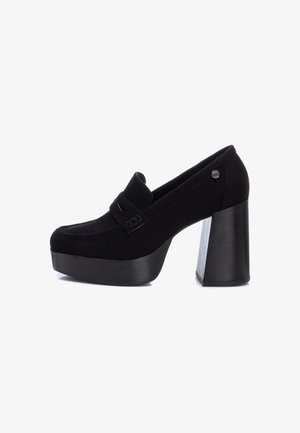 Mocassin à plateforme noir avec talon carré large, bout arrondi et détail de sangle décorative sur le dessus.