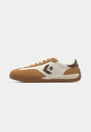 Low-profile sneaker with a cream textile upper and tan suede accents. Features a brown star logo and textured rubber sole for grip.