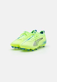 Crampons de football vert lime avec des accents bleus, en matériau synthétique léger, surface texturée et petits crampons pour l'adhérence.