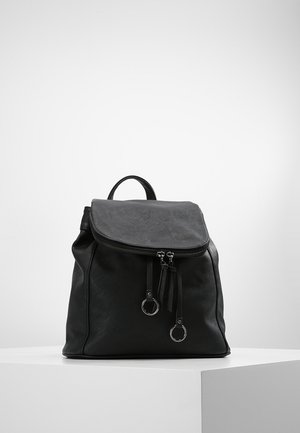 Černý batoh z umělé kůže se zipovým uzávěrem, trojúhelníkovým klopou a dvěma třásněmi vpředu. Má kovové stříbrné doplňky a jednu horní rukojeť.