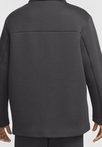 Ciemnoszara bluza z gładką, matową fakturą, o lekko oversize'owym kroju, z okrągłym kołnierzem i karczkiem z tyłu.