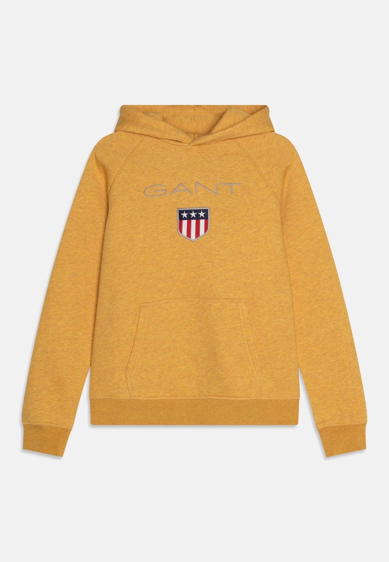Sweat à capuche jaune moutarde avec poche avant, logo "GANT" et emblème de bouclier comportant trois étoiles et des rayures rouges.