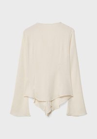 Cremig gerippter Langarmpulli mit asymmetrischem, geschichtetem Saum und leicht ausgestellt geschnittenen Ärmeln, von hinten gezeigt.