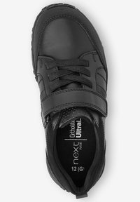Baskets en cuir noir avec des accents en textile, dotées de lacets et d'une sangle Velcro. À l'intérieur, on peut voir le logo "next Ultra" et l'étiquette de taille.