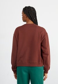 New Balance ATHLETICS CREST CREW - Melegítőfelső - rich oak