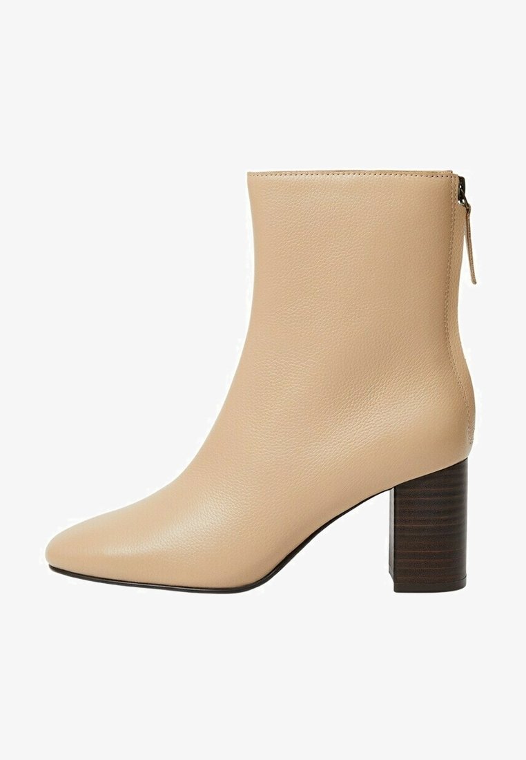 Bottine beige en cuir avec fermeture éclair latérale et talon bloc empilé marron foncé, bout pointu et texture lisse.