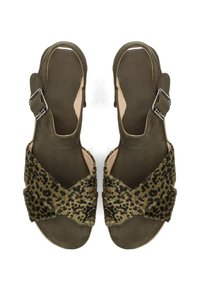 Sandali open-toe in suede verde con cinturini incrociati in pelliccia a stampa leopardata e cinturini alla caviglia regolabili, mostrati dall'alto su sfondo bianco.