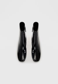 Schwarze Lackleder-Ankle Boots mit spitzem Zeh, Reißverschluss an der Seite und einer eleganten, glatten Textur.