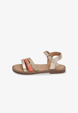 Riemchensandalen in metallischem Beige und Koralle mit Glitzerelementen. Flache Sohle, verstellbarer Knöchelriemen und ein glattes Lederfußbett.