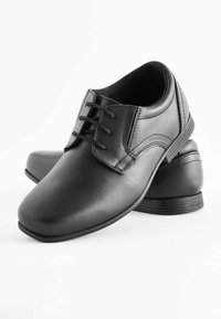 Chaussures de ville en cuir noir avec un bout arrondi, un laçage et de subtils détails de couture ; semelle en caoutchouc bas pour la stabilité.