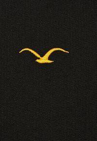 Black knit fabric featuring a yellow embroidered bird logo centered on the material, showcasing smooth texture and clear design contrast.