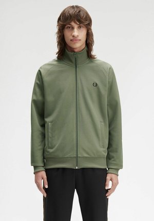 Chaqueta de cremallera verde olivo con cuello alto, puños y dobladillo acanalados, bolsillos frontales y logo bordado en el pecho, fabricada con tela suave.
