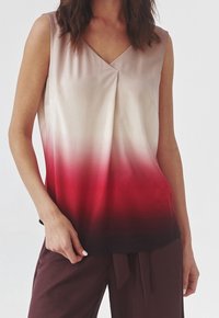 Top sans manches avec un col en V, présentant un dégradé allant d'un beige clair à un rouge profond, fabriqué en tissu lisse avec une coupe ample.