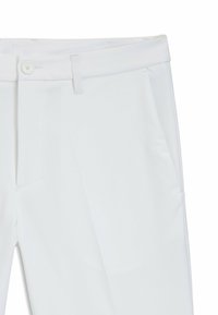 Pantaloni bianchi con una texture liscia, chiusura con bottone e tasche laterali. Il tessuto sembra leggero con un design sartoriale.
