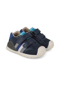 Zapatos infantiles de color azul marino con correas de velcro, que presentan rayas en gris claro y plata. Suela de goma con punta texturizada y plantilla acolchada.