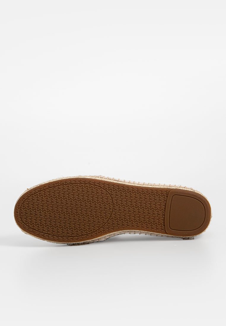 Calzature con suola in gomma testurizzata di colore marrone chiaro, caratterizzate da una superficie di presa a motivi e bordi cuciti. Design resistente e casual.
