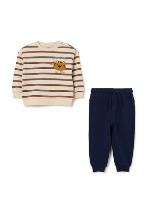 Beige langærmet sweatshirt med striber og tigerpatch samt marineblå joggebukser med elastik i taljen til børn.