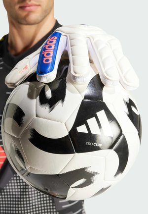 Adidas Tiro Club voetbal, zwart en wit met grafische patronen, vastgehouden door een gehandschoende hand. De handschoenen zijn wit met blauwe en roze accenten.