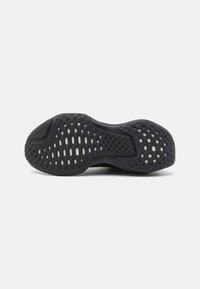 Talpa de pantof sport negru, dotată cu cauciuc texturat și decupaje hexagonale și circulare, oferind aderență și flexibilitate.