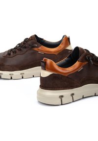 Baskets en cuir suédé marron avec des accents en cuir beige, tissu texturé, fermeture à lacets et semelles en caoutchouc crème, avec un col et un talon rembourrés.