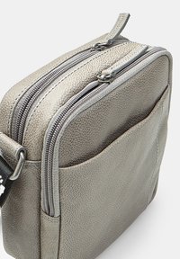 Borsa in pelle grigia texturizzata con doppia cerniera, tasca frontale e tracolla regolabile. Caratterizzata da un design robusto e una forma elegante.
