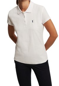 Polo blanc à manches courtes en coton, avec un col classique, une patte de boutonnage à trois boutons et un petit logo bleu marine sur la poitrine.