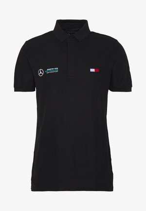 Zwart polo met korte mouwen en het Mercedes AMG Petronas Motorsport-logo op de linkerborst en een kleine vlag in rood, wit en blauw van Tommy Hilfiger op de rechterborst.