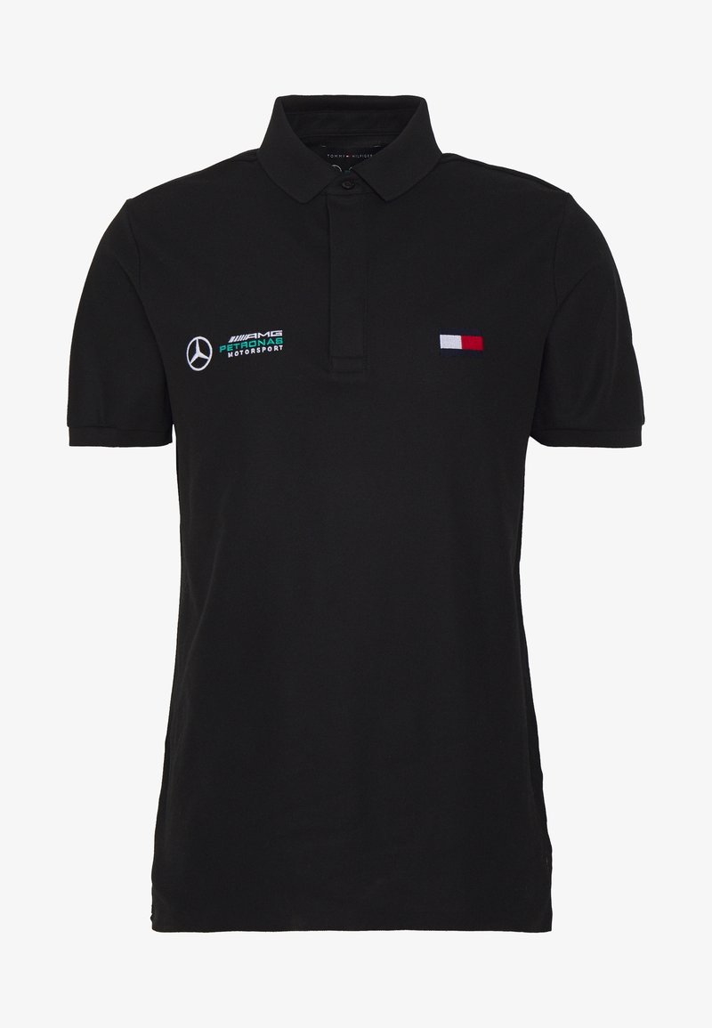 Polo noir à manches courtes avec le logo Mercedes AMG Petronas Motorsport sur la poitrine gauche et un petit drapeau Tommy Hilfiger rouge, blanc et bleu sur la poitrine droite.