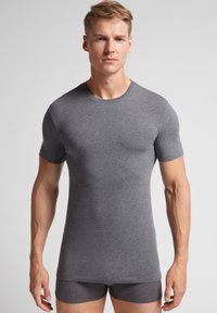 Szary T-shirt z krótkim rękawem, wykonany z miękkiej tkaniny, dopasowany krój, okrągły dekolt. W zestawie z pasującymi szarymi szortami. Gładka faktura i minimalne detale.