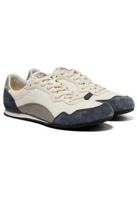 Białe i granatowe zamszowe sneakersy z teksturowaną powierzchnią, okrągłym noskiem, sznurówkami i subtelnym szarym akcentem przy pięcie. Lekką gumową podeszwą.