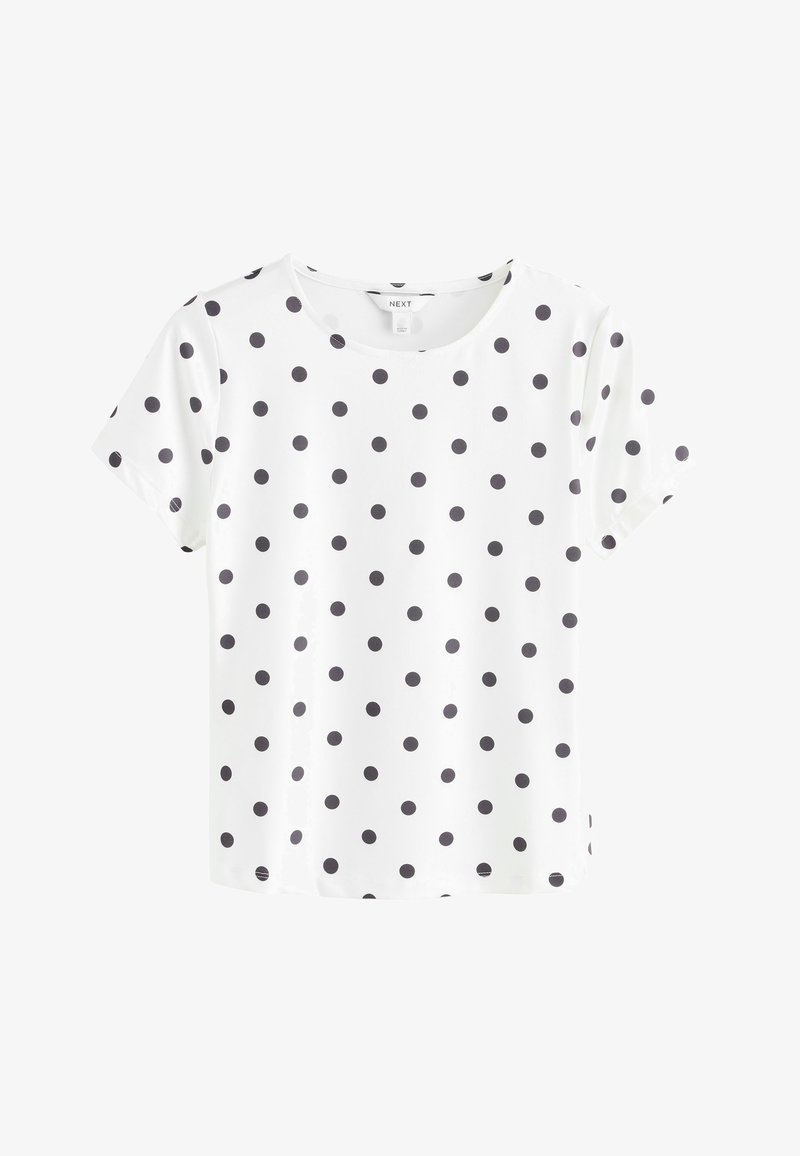 Blouse blanche à manches courtes avec des pois noirs, col rond et ourlet droit, présentée sur un fond blanc uni.