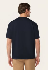Marineblauwe t-shirt met korte mouwen van katoen, met een ronde hals en een relaxte pasvorm. Subtiele logodetail aan de achterkant, vlakbij de hals.