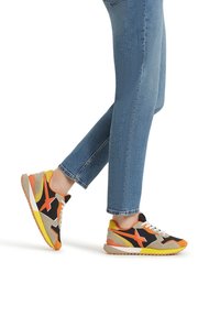 Sneaker multicolori con nubuck nero, arancione e beige, dotati di una suola testurizzata. I lacci bianchi e il design a profilo basso completano l'aspetto.