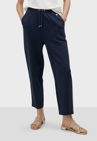 Mornarsko plavi hlače s pojasom na vezicu, s bočnim džepovima i ravnim krojem. Glatka tkanina s kontrastnim bočnim prugama.