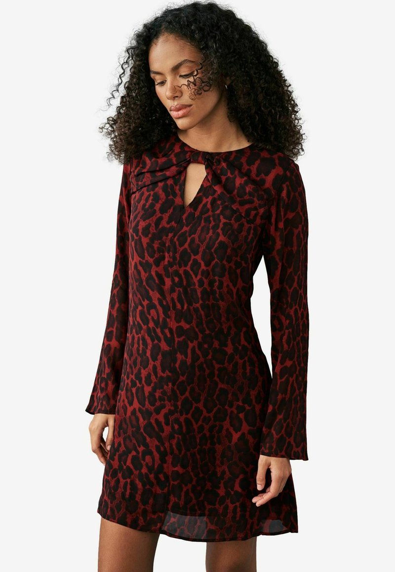 Rotes und schwarzes Leopardenmuster-Kleid mit langen Ärmeln und einem Schlüssel-Ausschnitt. Weicher, leichter Stoff mit einem fließenden Design.