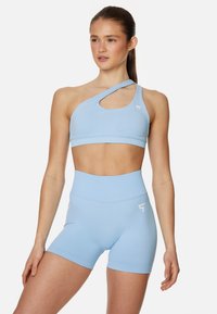 Light blue athletic set featuring a one-shoulder crop top with a cutout and high-waisted shorts, made from smooth, stretchy fabric.