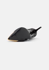 Czarne lakierowane szpilki z ostrym noskiem i złotym akcentem na podeszwie, charakteryzujące się gładką, błyszczącą teksturą oraz eleganckim designem.