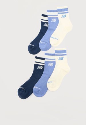 Șase șosete atletice până la gleznă în nuanțe de bleumarin, albastru deschis și crem, fiecare având două dungi și logo-ul „NB” pe manșetă și textul „New Balance” pe vârf.