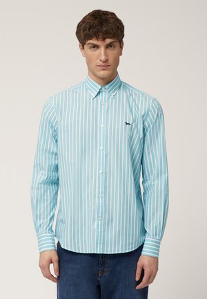 Light blue striped shirt with vertical white and pink stripes, buttoned collar, long sleeves, and a small dark logo on the chest.