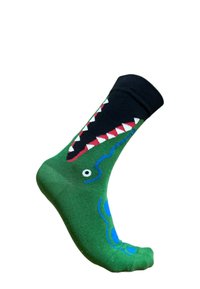 Grøn sok med et alligatordesign, der har en sort top, røde tænder, blå detaljer og et hvidt øje. Blød tekstur og tætsiddende form.