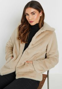 Beige faux fur jakke med krave, knapfront og sidelommer, der har en blød tekstur og en afslappet pasform.