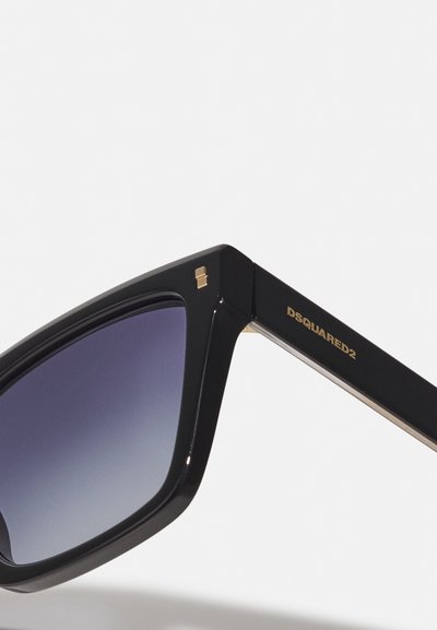 Sorte rektangulære solbriller med gradient linser, en blank overflade, detaljer i guld og et logo ætset på stangen.