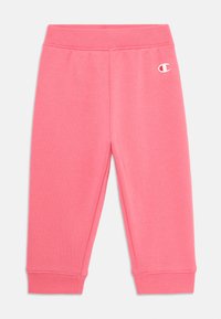 Pantalons de survêtement pour enfants, couleur rose, avec taille élastique et poignets, présentant un petit logo Champion blanc sur la cuisse supérieure gauche.